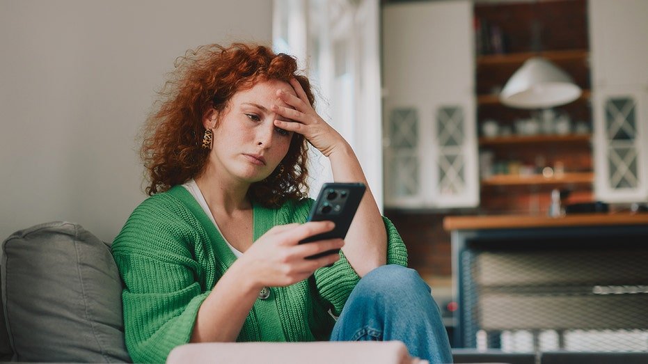 Woman looking stressed at the phone