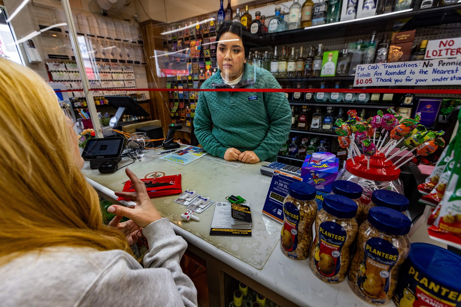 Claudia Cabrera of Wonderland Liquor Store in Revere listens to nurse Denise Hartley during naloxone training. (Jesse Costa/WBUR)