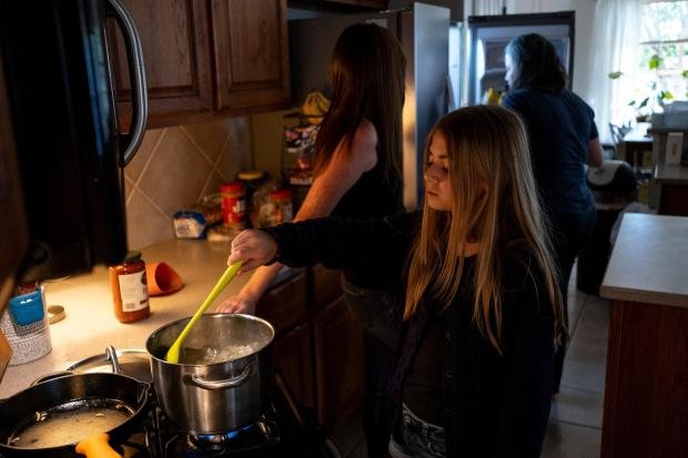 How to talk to your children about money 8 Ivy Edgar, 10, cooks pasta with her parents Jessica Edgar-Corum...