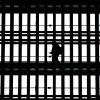 In this file photo, a man walks with a smartphone through the arched windows of Grand Central Terminal in New York City on March 24, 2025.