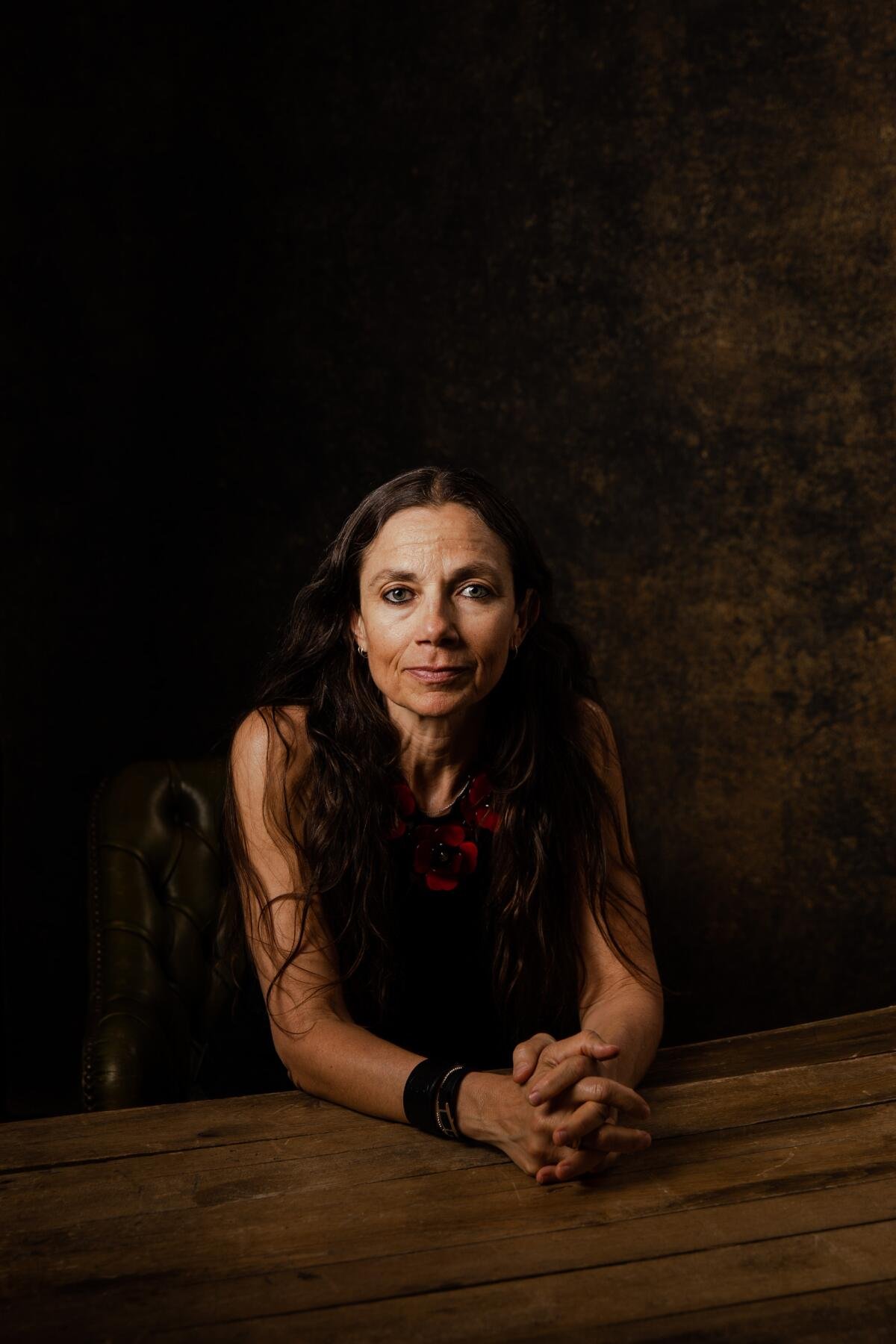     A woman in a dark top poses for the camera.