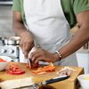 Close-up of a man in his 20s cutting peppers and preparing meals in the kitchen at home.
