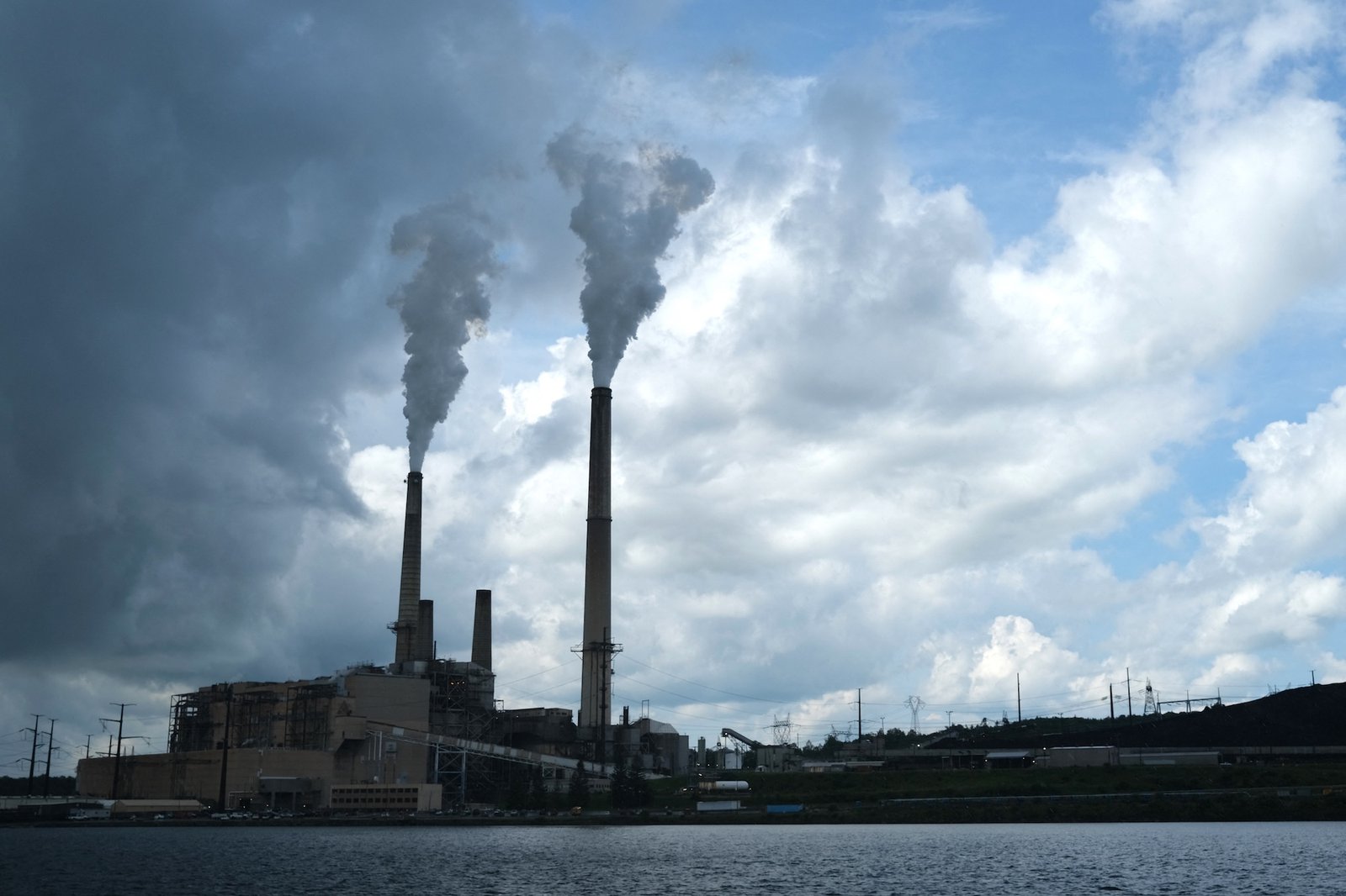 China's solar industry is losing money. The country is doubling anyway. 5 Smoke rises from the chimneys of a coal-fired power plant against a cloudy blue sky