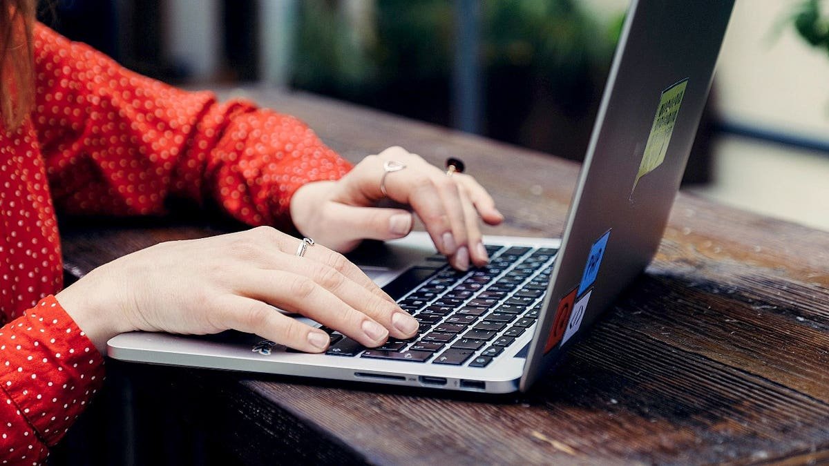 A woman is typing on the computer