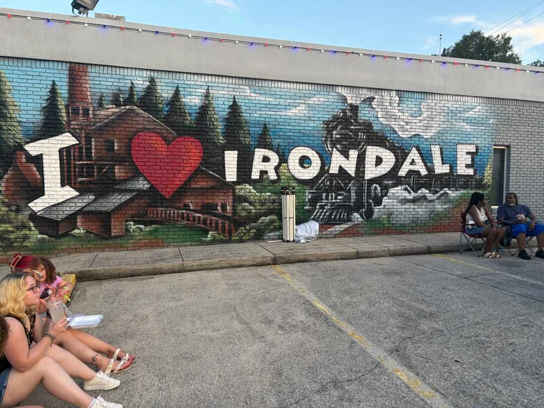 Festival goers sit in front of City Hall in Irondale, Alabama, on I Love Irondale Day, July 18, 2026.