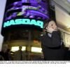 In this photo from 2000, a woman walks past the illuminated Nasdaq sign in New York's Times Square with a cell phone to her ear.