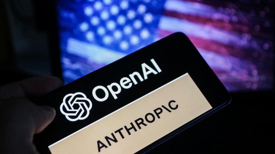 A smartphone screen shows the OpenAI and Anthropic logos against a blurred American flag background. 