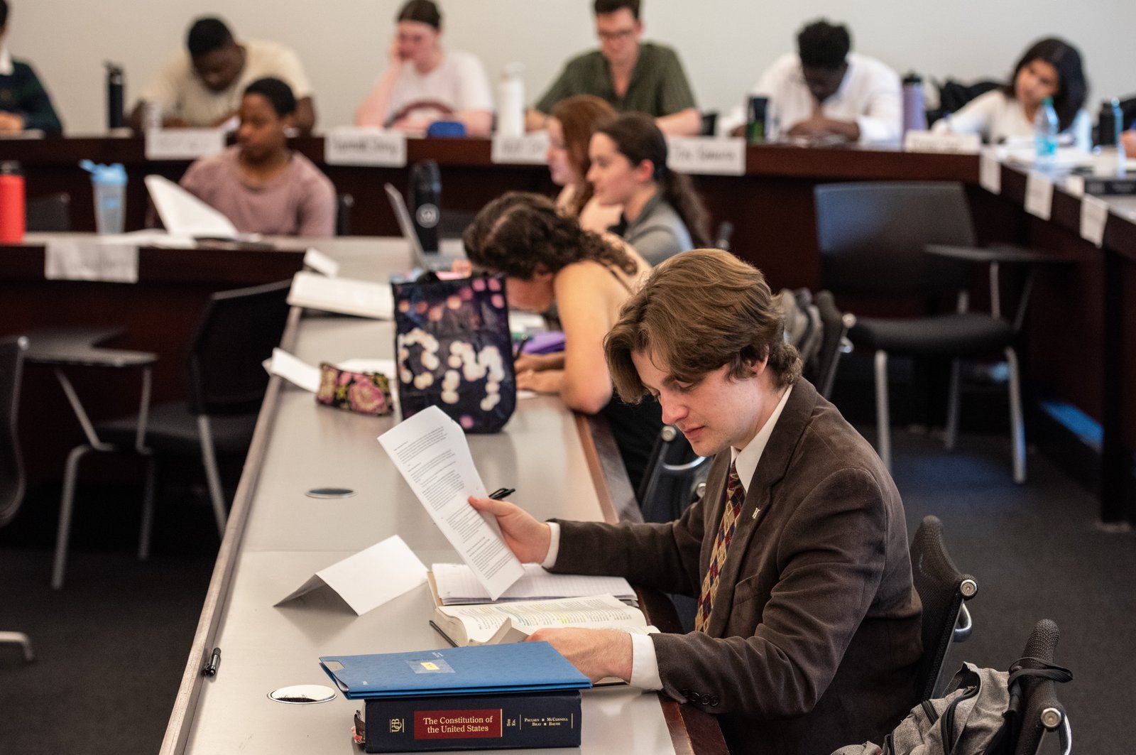 Students sit in a classroom and look with their heads at the papers in front of them